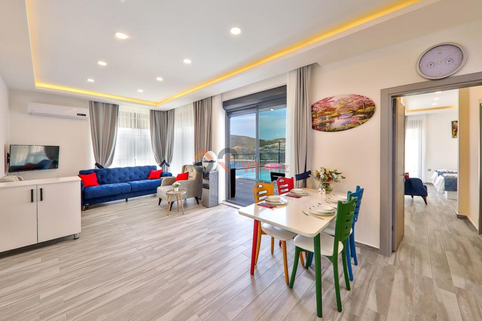 Mavi koltuklu oturma alanı ve yemek masası bulunan iç mekân.