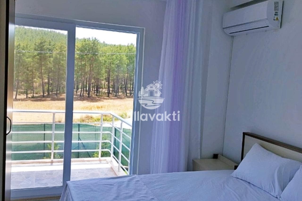 Yatak odasından orman manzaralı balkona açılan cam sürgülü kapı.