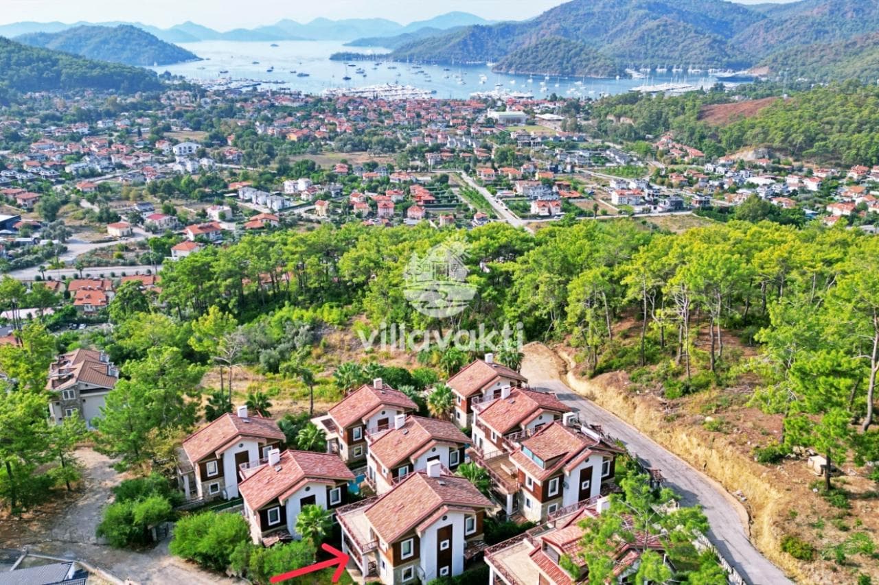 Ormanlık alan ve deniz manzaralı yerleşimin yukarıdan genel görünümü.